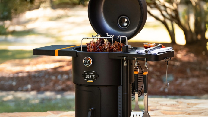 Oklahoma Joes Bronco series drum smoker featuring a rib hanging kit and split grates