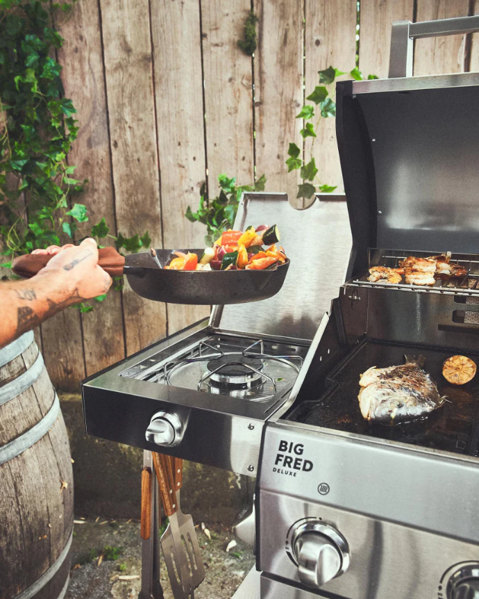 Cooking with a cast-iron skillet on the integrated side burner of a Burnhard Big Fred Deluxe gas grill