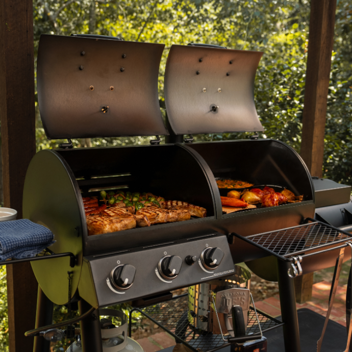Oklahoma Joes Canyon dual fuel combo grill smoking meat and searing steaks simultaneously