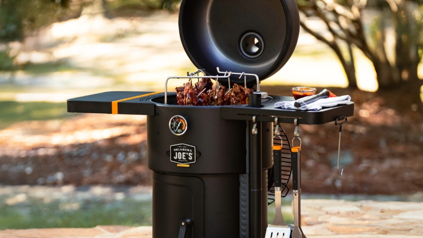 Oklahoma Joes Bronco drum smoker cooking ribs for authentic live fire outdoor BBQ